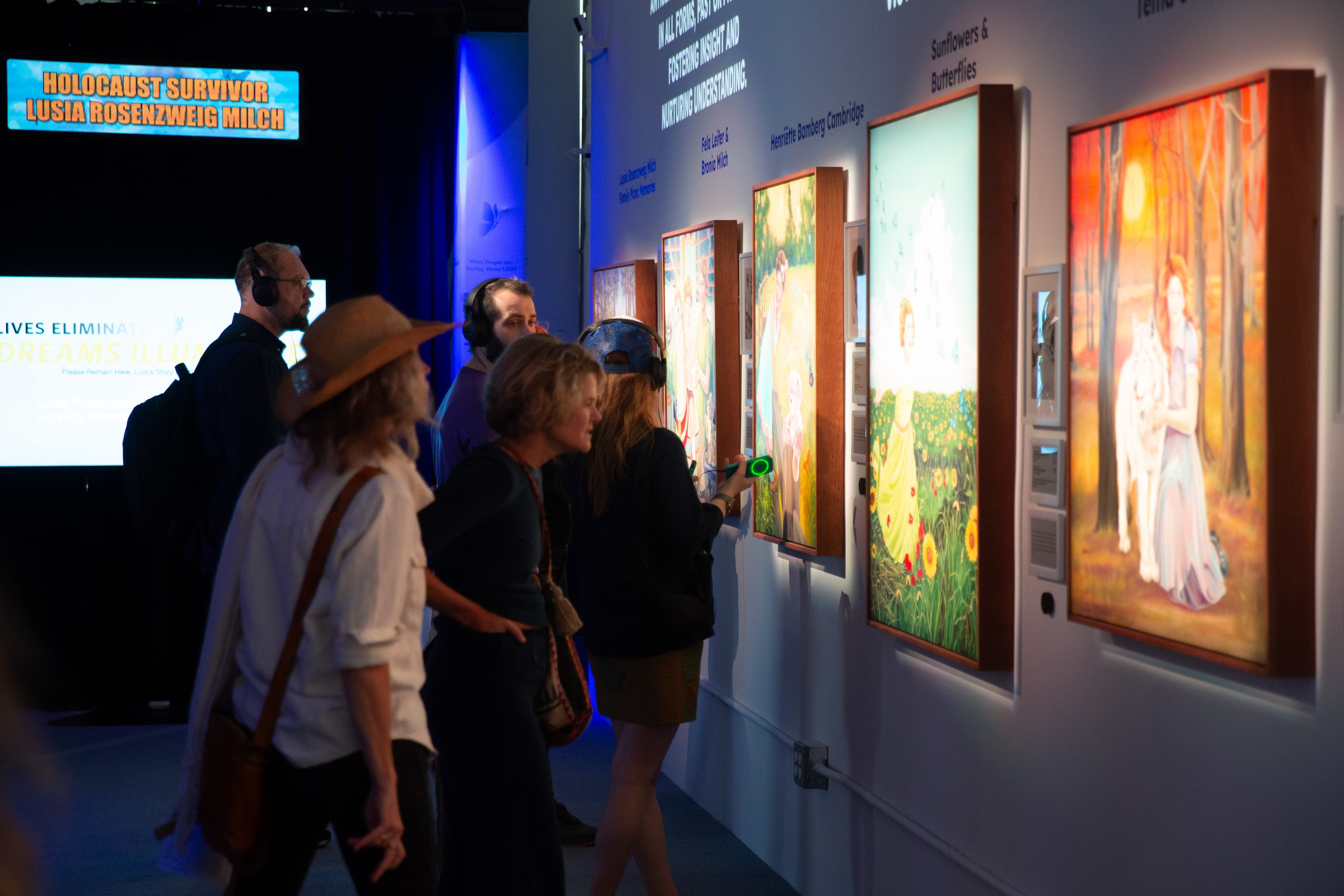 Visitors viewing paintings at LEDI Center exhibit